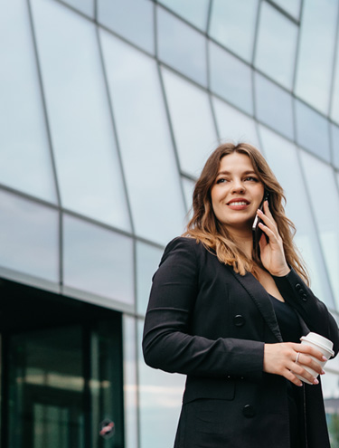 Jeune femme au téléphone, souriante et regardant au loin