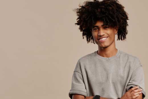 Jeune homme souriant, bras croisés face à la caméra
